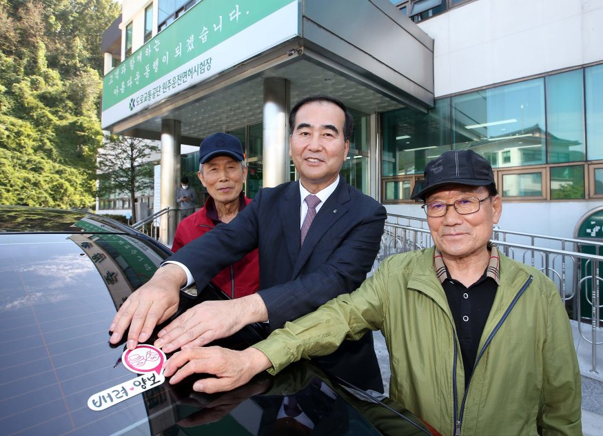 사진2. 스마일실버 스티커를 차량에 부착하고 있다.jpg